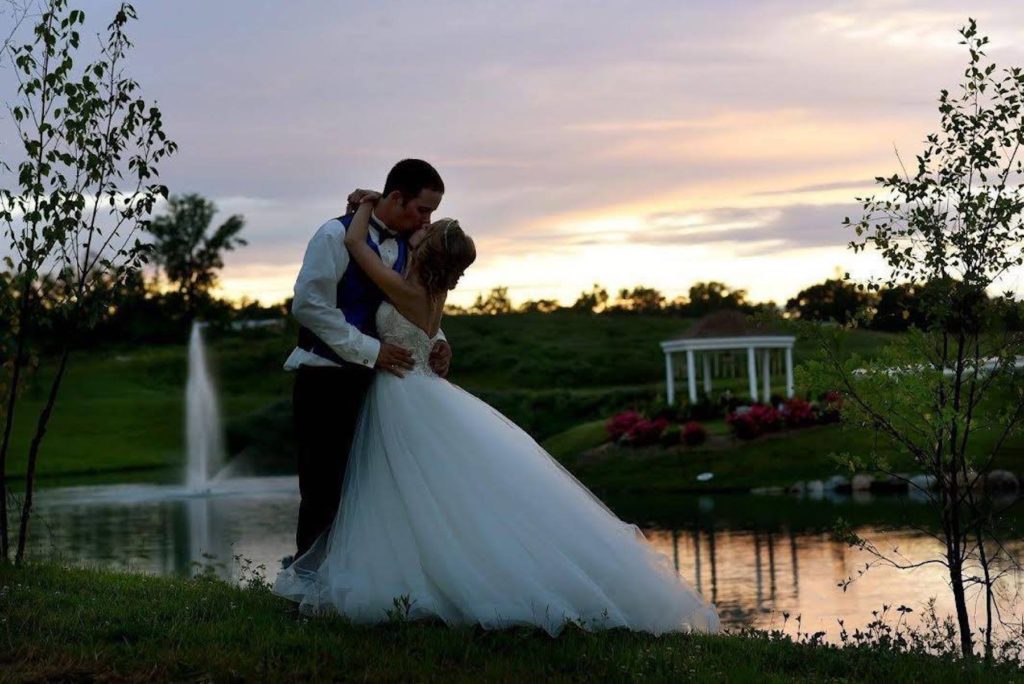 outdoor wedding on the water with sunset backdropo