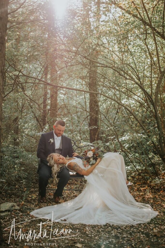 elegant bride and groom posed with whimsical forest backdrop