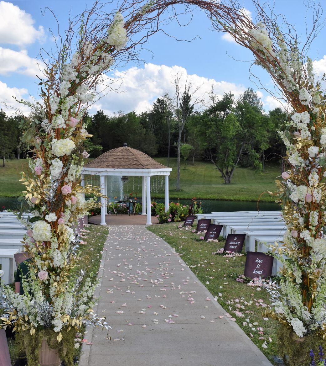 floral entrance arch at outdoor wedding ceremony
