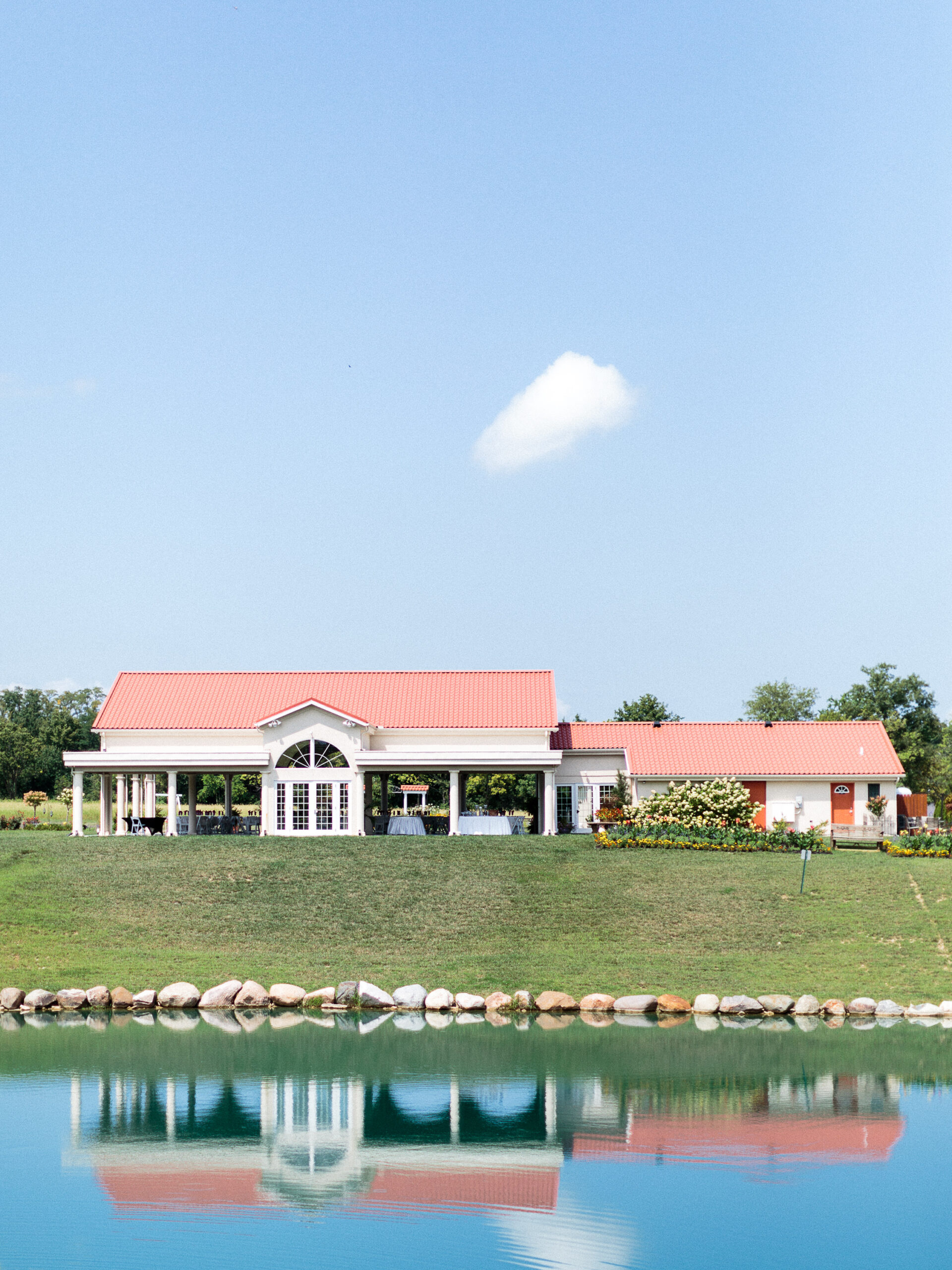 Mediterranean italian style wedding venue positioned in front of tropical blue pond