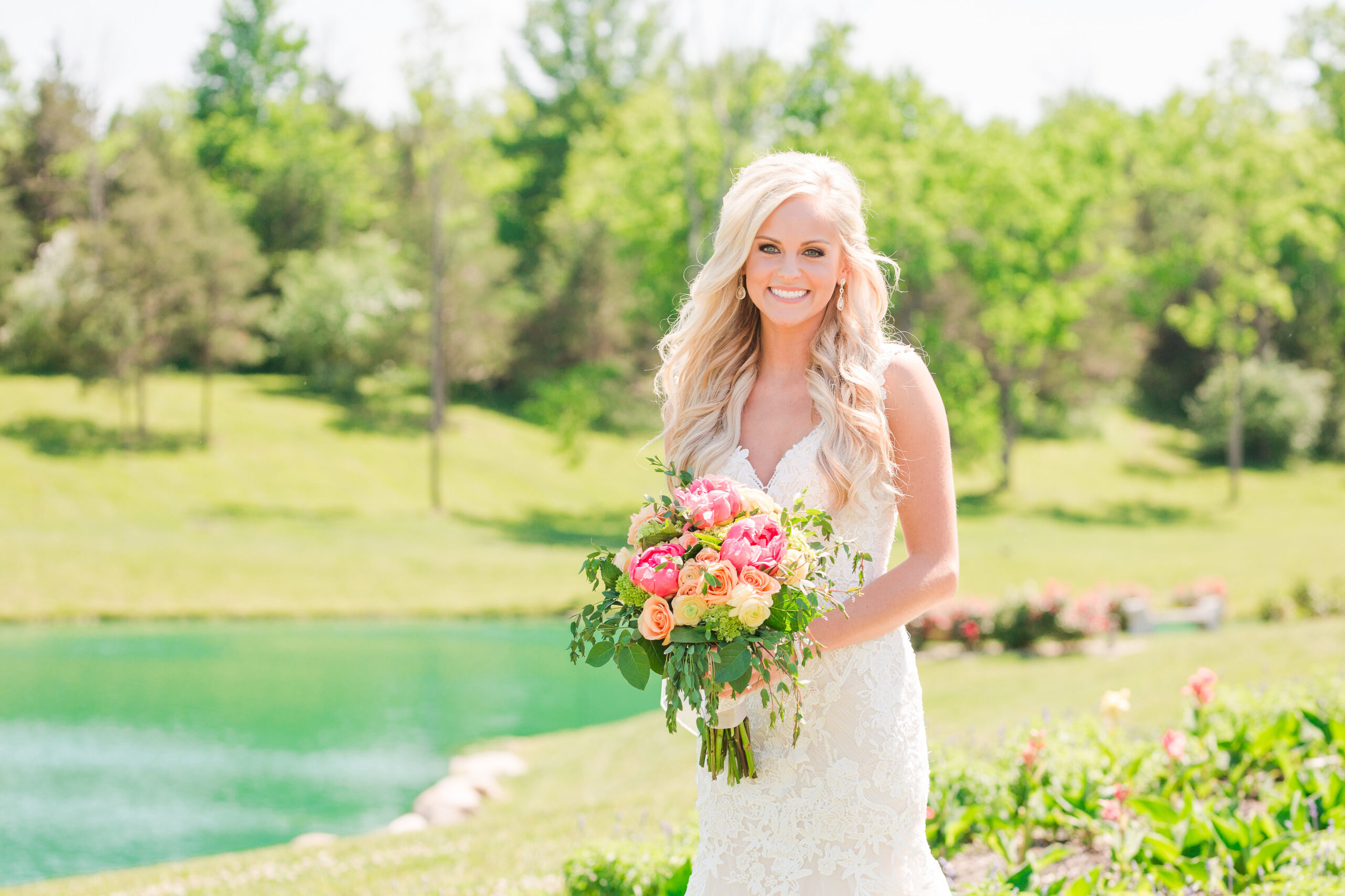 bride posing in front of tropical looking pond