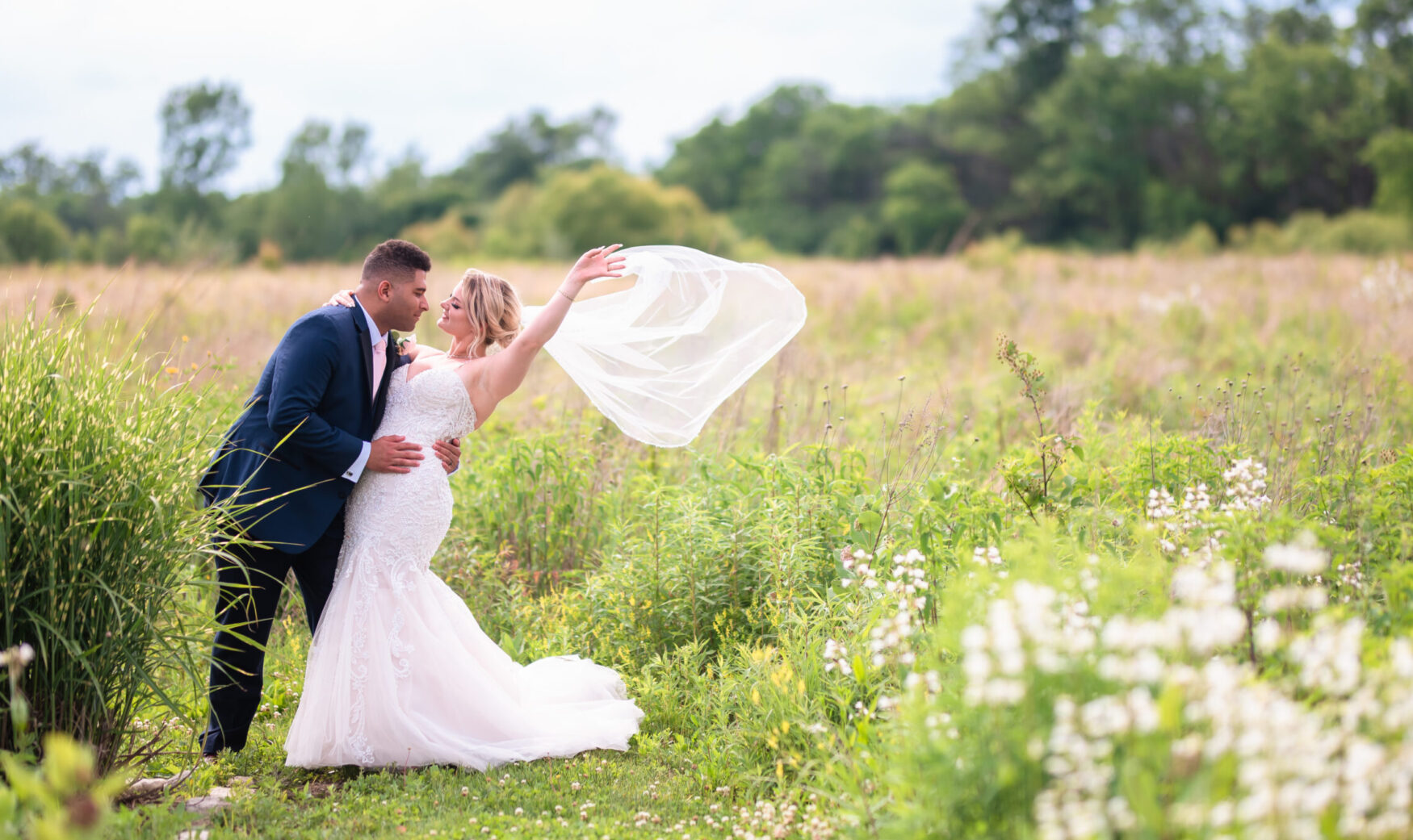 bride and groom posing in wildflower meadow
